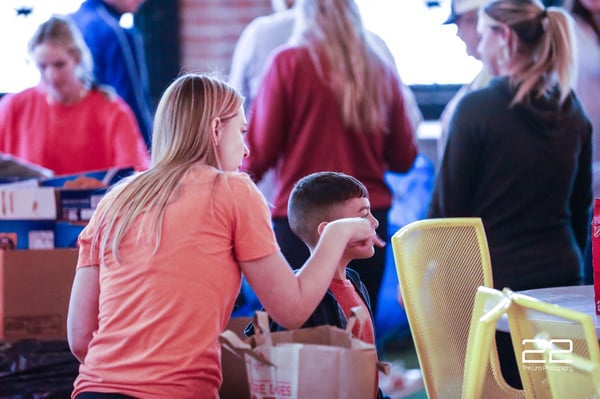 Volunteers working together to assemble Thanksgiving baskets