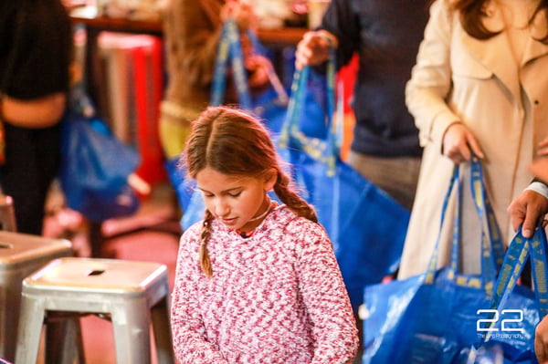 A young volunteer helping at an HTX Basket Brigade build